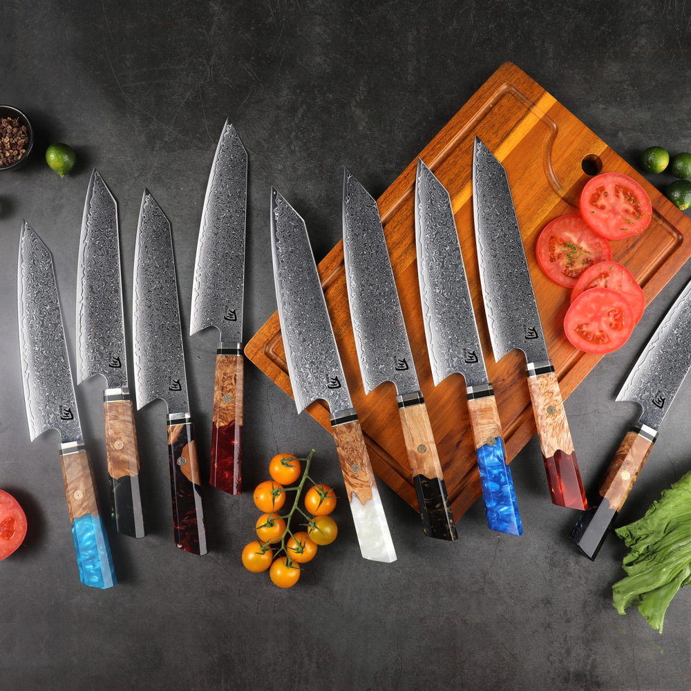 Set of Damascus steel kitchen knives with wooden handles on a cutting board with vegetables.